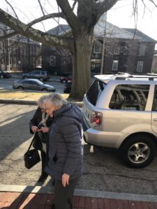 Two older ladies look at their smartphone so that they can use the app to take a ridehail trip.